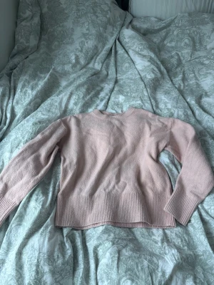 Ljusrosa stickad tröja & Other Stories - Supersöt ljusrosa stickad tröja från & Other Stories. Tröjan har rund halsringning, långa ärmar och bred ribbstickad kant nedtill och vid ärmsluten. Perfekt att matcha med jeans eller kjol för en chill look.