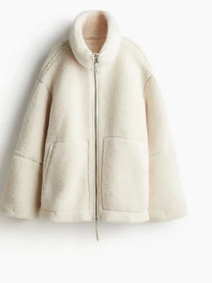 Beige teddyjacka med dragkedja - Supermjuk och oversized teddyjacka i beige med hög krage och stora fickor framtill. Jackan har hel dragkedja och är perfekt för kyliga dagar. Den fluffiga looken ger en trendig och avslappnad vibe.