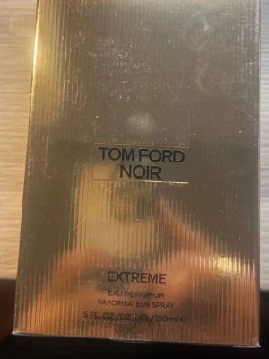 Tom Ford Noir Extreme EdP 150 ml - Lyxig parfym från Tom Ford, Noir Extreme Eau de Parfum i en elegant guldfärgad förpackning. Flaskan rymmer 150 ml och har en exklusiv och modern design som verkligen sticker ut. Perfekt för dig som gillar intensiva och sofistikerade dofter. Kvittot medföljer köpt i lyko som present men har redan en samma. Även plasten är kvar