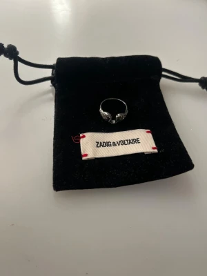 Zadig Voltaire ring - Säljer denna superfina silverringen från Zadig Volaire i storlek 52. Ett fåtal stenar som ramlat av (se bild 3) men annars ett bra helhetsintryck. Påse medföljer💞bara att höra av sig vid funderingar 