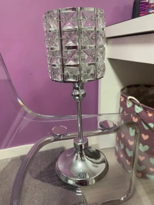 Silverfärgad ljushållare i kristallstil - Snygg ljushållare i silverfärgad metall med cylinderformad hållare dekorerad med klara kristalliknande detaljer. Perfekt som dekoration på bord eller hylla för att skapa mysig stämning med värmeljus.