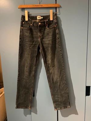 Mörkblå raka jeans från 157 - Snygga mörkblå jeans från 157 med klassisk femficksdesign och raka ben. Jeansen har orangea sömmar och silverfärgad knapp framtill. Perfekta för en avslappnad och stilren look.