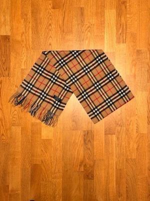 Beige Burberry halsduk - Säljer en beige halsduk från Burberry. Halsduken är i fint skick och är gjord i 100% lamull. Var inte rädd för några frågor. Pris diskuteras inte!