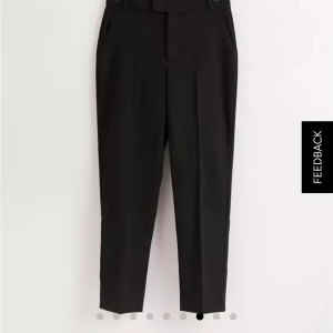 Svarta kostymbyxor Lindex storlek 38 - Svarta kostymbyxor från Lindex i modellen Polly, hög midja och croppad längd. Klassisk rak passform med pressveck, bälteshällor och fickor i sidorna. Perfekta för en clean och stilren look. Inköpta på Lindex Karlstad. Aldrig använda, lappen kvar.