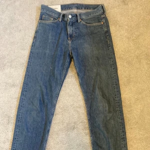 Blå relaxed fit jeans från H&M - Säljer ett par blå jeans från H&M i relaxed fit. Klassisk femficksmodell med normal midja och raka ben. Jeansen är tillverkade i bomull och har en snygg, enkel tvätt som passar till det mesta. Perfekta för dig som gillar en avslappnad stil.