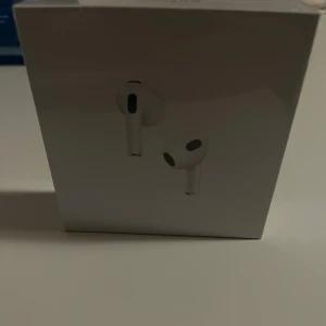 Apple AirPods (3rd generation) med MagSafe-laddningsetui - Helt nya Apple AirPods (3rd generation) med MagSafe-laddningsetui, oöppnad originalförpackning. Trådlösa hörlurar med hög ljudkvalitet, lång batteritid och smidig laddning. Perfekt för musik, samtal och träning. Ingen synlig skada på förpackningen.