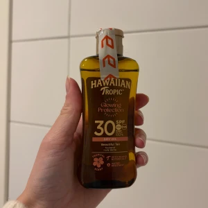 Hawaiian Tropic Glowing Protection SPF 30 - Säljer en brun plastflaska med Hawaiian Tropic Glowing Protection Dry Oil SPF 30. Oljan ger en vacker solbrun ton och har tropisk doft. Innehåller botaniska extrakt och är vattenresistent. Flaskan rymmer 100 ml och har en praktisk skruvkork. Köptes inför resa men användes aldrig 