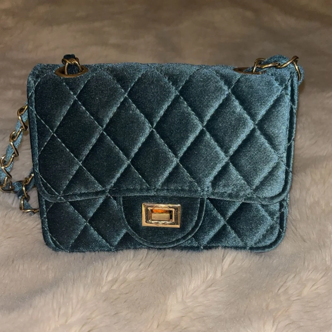 Quiltad blå axelväska.