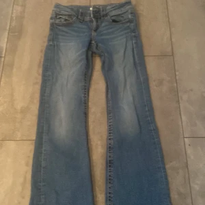 Blå jeans från Gina Tricot, stl 152 - Säljer ett par klassiska blå jeans från Gina Tricot i storlek 152. Säljs inte längre!! Jeansen har raka ben, fem fickor och normal passform. Perfekta till vardags med en snygg tvättad look och klassiska detaljer som synliga sömmar och bälteshällor.