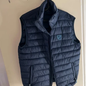 Djurgården väst - Snygg marinblå dunväst från Djurgården med klubbmärke på bröstet, storlek M. Använd 1 gång då den va för stor för mig