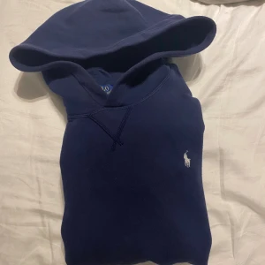 Ralph Lauren hoodie - Snygg marinblå hoodie från Polo Ralph Lauren i storlek xl i barn men sitter som en S. Tröjan har huva och klassisk vit logobrodering på bröstet. Tillverkad i mjuk bomull, perfekt för chill dagar. Enkel design med ribbade muddar och skön passform. Tröjan är köpt för ca 1500, mitt pris 700, jättebra skick
