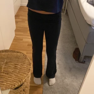 Svarta bootcut byxor Gina Tricot - Svarta bootcut byxor från Gina Tricot i stretchigt bomullsmaterial. Hög midja med bred linning som kan vikas ner. Snygg passform med utsvängda ben, perfekta till en chill och trendig look. 