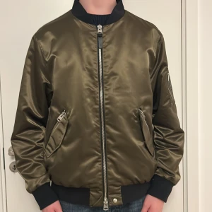 Mackage Bombarjacka  - Säljer en olivgrön bombarjacka från Mackage. Den är så gott som ny, endast använd några få gånger. Jackan är i storlek 46, vilket ungefär motsvarar large. Nypriset ligger på 5000+kr