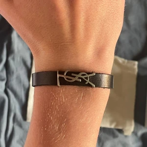 Saint Laurent armband - Jätte fint YSL armband i otroligt fint skick, alla tillhörigheter medföljer (se bild). Och såklart är det äkta 🙂.