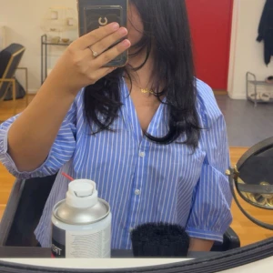 Blåvit randig skjorta med knappar - !! Varan säljs inte längre så passa på !!Säljer en blå skjorta med vita ränder och v-ringning som köptes i juni. Skjortan har trekvartsärmar med lätt puff och knäppning framtill. Perfekt för dig som gillar en avslappnad men ändå stilren look. St M, har två andra färger också( skriv privat )