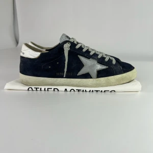 Golden Goose sneakers  - Snygga sneakers från Golden Goose i mörkblå mocka med grå snörning och silverfärgad stjärndetalj på sidan. Dustbag tillkommer!