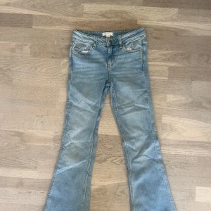Bootcut jeans från Gina Tricot ljusblå - Snygga ljusblå bootcut jeans från Gina Tricot med klassisk femficksdesign och dragkedja. Jeansen har en lätt tvättad look och är tillverkade i mjukt denimtyg med skön stretch. 
