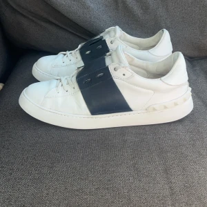Valentino Garavani Open sneakers vit/blå - Använda men mycket fina. Självklart äkta. Färgen är Navy och storleken 43. Skulle säga att de funkar för 43,5 också 