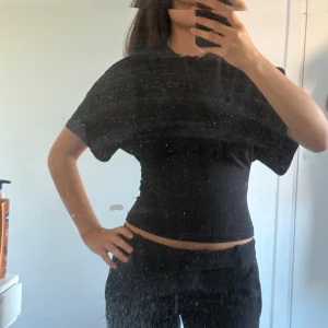 T-Shirt från Nelly - Supersnygg svart t shirt från Nelly storlek xxs, inte använd så ofta därav säljer jag! Den är tajt vid midjan 