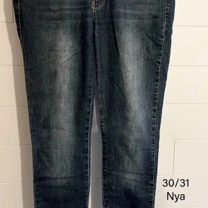 Mörkblå jeansbyxor i rak modell - Snygga mörkblå jeansbyxor med klassisk tvätt och raka ben. Jeansen har fem fickor och tydliga sömmar baktill. Perfekta för dig som gillar en enkel och tidlös stil. Passar till det mesta och är riktigt bekväma.