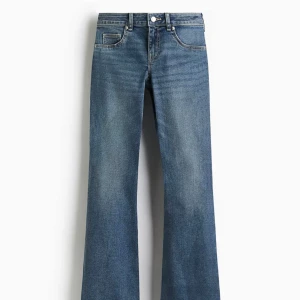 Blåa bootcut jeans med låg midja H&M - Snygga blå jeans med bootcut-modell och låg midja. Jeansen har klassisk femficksdesign och är tillverkade i ett mjukt denimtyg. Perfekta för dig som gillar en retroinspirerad look med utsvängda ben. Uppsprättade där nere😇aldrig användna
