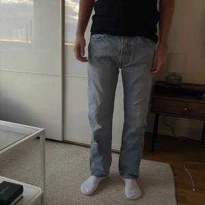 Levis 501 ljusblå jeans straight fit - Ljusblå Levis 501 jeans med klassisk rak passform och femficksdesign. Jeansen har normal midja och är tillverkade i mjukt denimtyg. Perfekta för en avslappnad och stilren look.