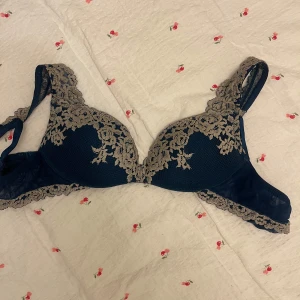 Mörkblå spets-bh med blommig detalj - Säljer min Blå  bh med vacker beige spets och blommiga detaljer från intimissmi🩵