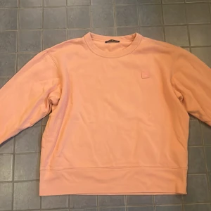 Acne Studios tröja - Säljer en sweatshirt från Acne Studios med det ikoniska Face-logotypen på bröstet. Storlek L men passar M