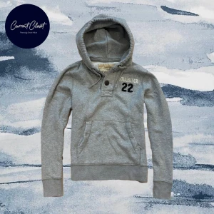 Grå hoodie från Hollister med tryck - Grå hoodie från Hollister med broderat vitt Hollister-tryck och svart siffra 22 på bröstet | Size M | Otroligt svår att få tag på, pris kan diskuteras | Längd: 65cm Axelbredd: 42cm