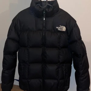Svart lhotse puffer från The North Face - Säljer en svart lhotse pufferjacka från The North Face med najs rutigt puffer mönster. Jackan är köpt för ett år sedan och bara använd förra vintern. Jackan är supervarm och skön och riktigt snygg. Priset kan diskuteras😁