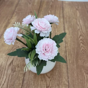 Blomma i plast  - Bilderna visar en konstgjord blomsterdekoration med ljusrosa blommor i en vit kruka. Det finns ingen bok på bilderna.