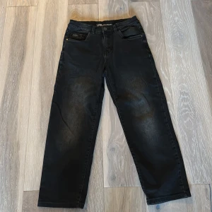 Svarta raka jeans från LAB - Svarta jeans från LAB med klassisk femficksdesign och raka ben. Jeansen har en diskret tvättad look och normal passform. Perfekta för dig som gillar en stilren och enkel vibe.