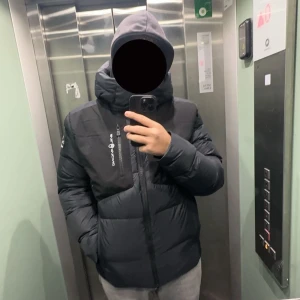 Svart sail racing  dunjacka  - Svart sail racing jacka storlek L men passar även M och man kan även ha på sig jackan på vinter/regn eller när de är kallt. Jackan har 4 fickor som är stora 3 utanför 1 inne i jackan. Denna jackan är varm och skön. Priset kan diskuteras 