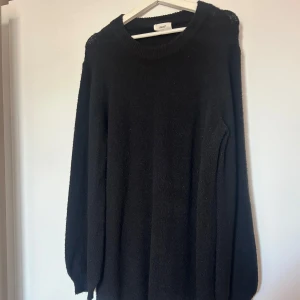 Svart stickad klänning från Object - En svart stickad klönning från Object i storlek L. Tröjan har rund halsringning, långa ärmar och ribbade muddar. Perfekt för dig som gillar en enkel och klassisk look med en mysig känsla.