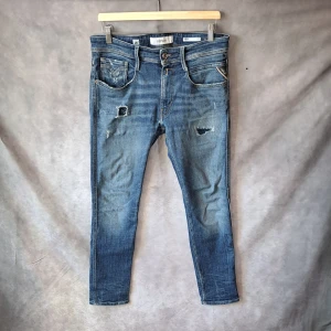 Replay Anbass Jeans, Aged 05 - Stl w31 l32 - Mycket bra skick, 8,7/10, en liten slitning vid grenen vet dock inte om det är en slitning från fabrik, annars toppskick! | Storlek: w31, l32 ska de vara, storleklappen är avklippt | Populär modell från Replay med snygga naturliga slitningar | Hör av dig vid frågor | Mvh Galgen ✌️