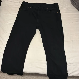 Svarta Levi's 501 jeans W34 L34 - Svarta Levi's 501 jeans med klassisk rak passform. Jeansen har knäppning framtill och är tillverkade i slitstarkt bomullstyg. Perfekta för dig som gillar en clean look. Diskuterar inte priset, använd ett fåtal gånger och ett sjukt bra pris på de. Inga skambud om du vill köpa så kontakta mig.