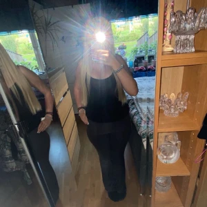 Svarta bootcut byxor - (Joga pants) Säljer ett par svarta byxor med bootcut-modell. De har en figurnära passform upptill och utsvängda ben nertill, vilket ger en snygg siluett. Perfekta för dig som gillar en klassisk och stilren look. Materialet känns mjukt och stretchigt för extra komfort.