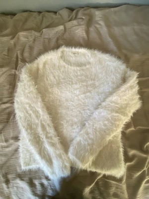 Vit fluffig tröja från H&M - Säljer en supermjuk och fluffig vit tröja från H&M i storlek 158/164. Tröjan har långärmade ärmar och en rund halsringning. Perfekt för dig som gillar mysiga och trendiga plagg med lite extra fluff. Passar dig som vill ha en chill och cozy stil.