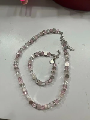 Halsband - Jag säljer ett halsband med ett matchande armband med rosa pärlor och silverfärgade pärlor. 