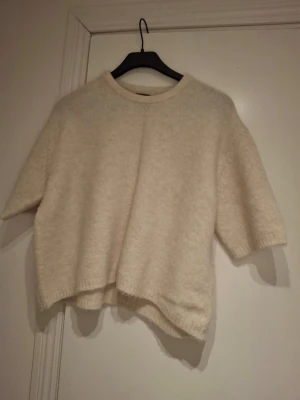Helt ny beige stickad tröja med kort ärm - Mysig och enkel stickad tröja från Lindex i beige färg med korta ärmar och rund hals. Tröjan har en loose passform och är perfekt för lager-på-lager. Materialet är mjukt och ger en skön känsla mot huden. Passar dig som gillar stilrena och avslappnade plagg. Storlek xs-s