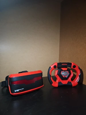 VR  - VR Real Feel Racing är ett VR-headset med ratt för racingspel. Kompatibel med gratis app för iOS och Android. Inkluderar force feedback för realistisk känsla. Produkten är i gott skick och levereras i originalförpackning. Du kan även använda den för att titta på filmer.