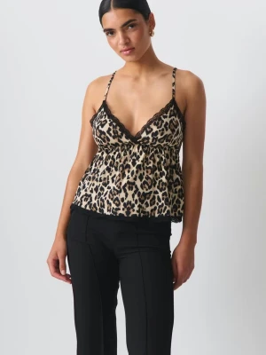 Leopardmönstrad linnetopp med spets - Säljer en snygg leopardmönstrad linnetopp med tunna axelband och svarta spetsdetaljer längs urringning och nederkant. Toppen har v-ringning och är lätt utsvängd nedtill, perfekt för att sticka ut lite extra. Materialet känns mjukt och följsamt.