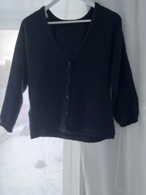 Mörkblå kofta med v-ringning - Snygg mörkblå stickad kofta med v-ringad hals och knappar framtill. Ärmarna är trekvarts vilket jag inte visste när jag köpte den så endast använd 3-4 gånger. Köpt från Nelly för 319kr. Priset kan diskuteras!!💕