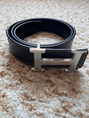 Svart H bälte - Säljer Svart Herrmes bälte i storlek 115cm. Det är i mycket bra skick och säljer det pågrund av reselling. Kom privat för fler frågor.
