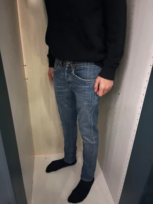 Dondup George  - Säljer ett par Dondup George-jeans i storlek 30/30. Jeansen är i mycket fint skick, 9–10, och sparsamt använda. Nypris ca 2 000–3 000 kr. Snygg passform och hög kvalitet. Benlängden är ca 96 cm och midjemåttet är ca 38 cm. Han på bilden är ca 175-180 cm. Hör av dig vid frågor eller för fler bilder.