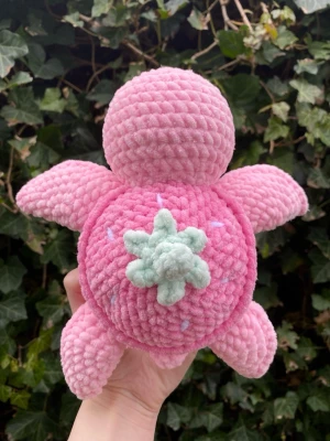 Virkad gosedjur sköldpadda - En supersöt sköldpadda med jordgubbs tema som är virkad. Den är väldigt fluffig och mjuk!   ‼️BRA ATT VETA:  Den går att göras i andra färger. Bara kontakta mig så kan vi komma överens om du önskar andra färger.   Den är inte lämplig för barn under 3 år pga plastögonen. 