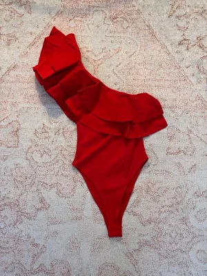 Röd body med volang - Sjukt snygg röd body från Zara med prislappen kvar. 