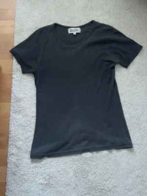Svart t-shirt från Blu di Blu - En enkel svart t-shirt från Blu di Blu i storlek S. Modellen har rund hals och korta ärmar, perfekt för en clean och chill look. Materialet känns mjukt och bekvämt, troligtvis bomull. Passar dig som gillar basic och stilrent.