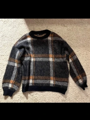 Stickad tröja  - Stickad tröja från Only. Mörkblå/orange/brun/vit i färg!