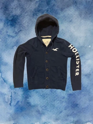 Vintage Hollister Cardigan Med Knappar - Säljer denna otroliga sällsynta och feta Hollister cardigan med knappar | Mycket bra skick | Längd ≈ 64cm, Bredd armhåla - armhåla 55 cm | Modell 175, 68kg | PRIS KAN DISKUTERAS!